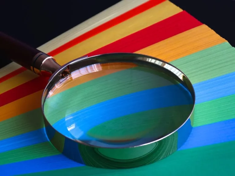 A magnifying glass on colored paper.